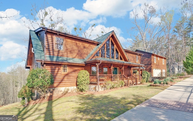 221 Laurel Cir, Dahlonega, GA 30533 - log-style house with a front yard, a porch, and stone siding