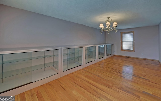 221 Laurel Cir, Dahlonega, GA 30533 - unfurnished room with a notable chandelier, a textured ceiling, and wood finished floors