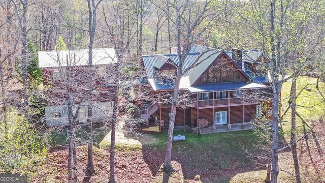 221 Laurel Cir, Dahlonega, GA 30533 - exterior space featuring metal roof, faux log siding, a front lawn, a view of trees, and a patio area