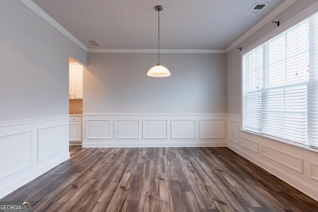 unfurnished dining area with ornamental molding, dark wood-style floors, a wainscoted wall, and a decorative wall