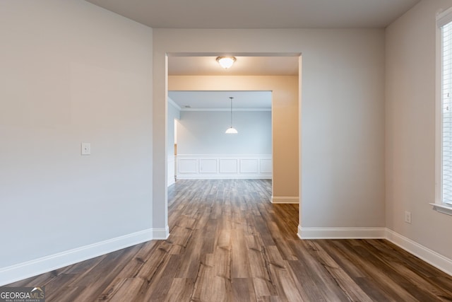 hallway with dark wood-style flooring, baseboards, and ornamental molding