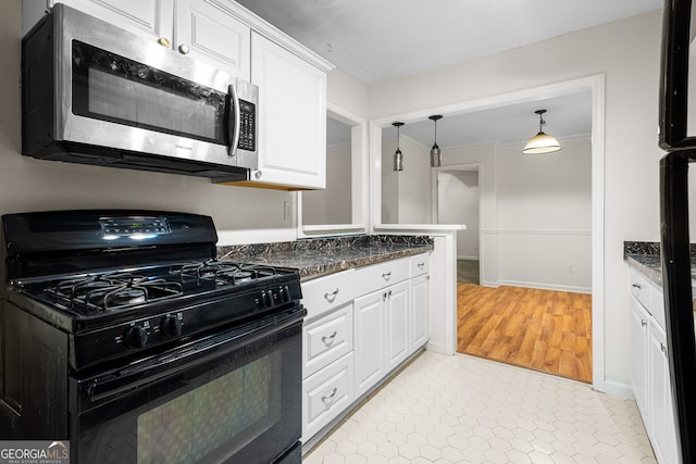 kitchen with white cabinets, hanging light fixtures, stainless steel microwave, and black gas range oven