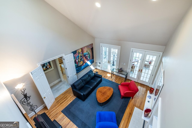 living area with high vaulted ceiling, baseboards, wood finished floors, recessed lighting, and french doors