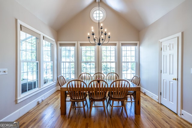 dining area with vaulted ceiling, a healthy amount of sunlight, a chandelier, and wood finished floors