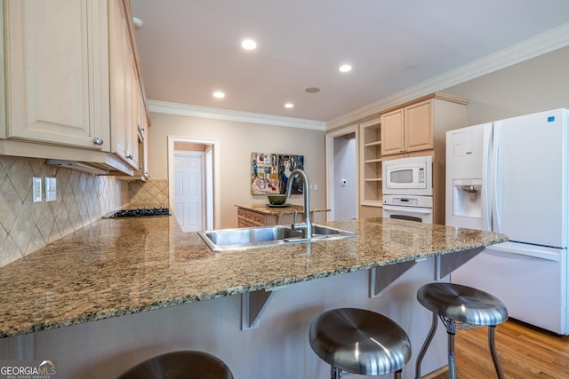 kitchen with crown molding, a sink, a peninsula, and white appliances