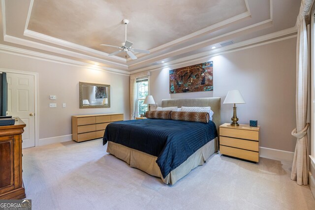 bedroom featuring visible vents, baseboards, ornamental molding, a tray ceiling, and light colored carpet