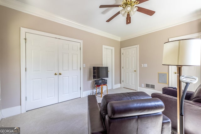 carpeted living room with baseboards, visible vents, crown molding, and ceiling fan