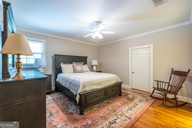 bedroom with baseboards, visible vents, ornamental molding, and light wood-type flooring