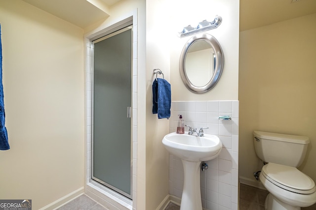 bathroom with an enclosed shower, tile walls, toilet, and tile patterned floors