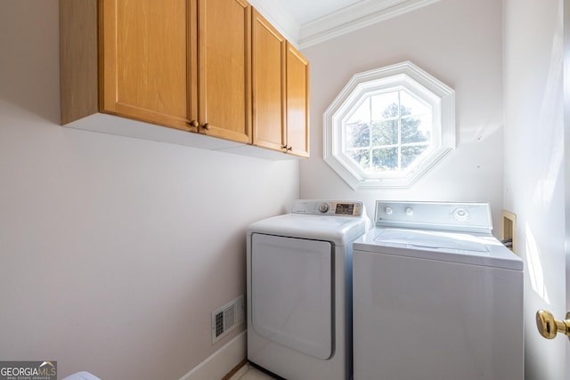 laundry area featuring separate washer and dryer, visible vents, cabinet space, and ornamental molding