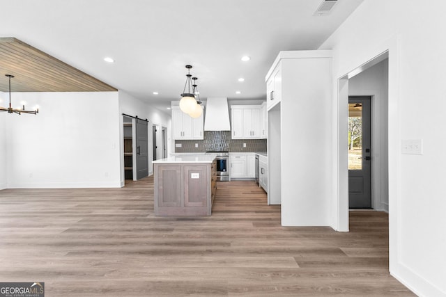 191 Lagrange St, Newnan, GA 30263 - kitchen with premium range hood, stainless steel range oven, a barn door, white cabinets, and light countertops