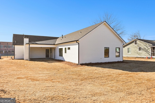back of property with a shingled roof