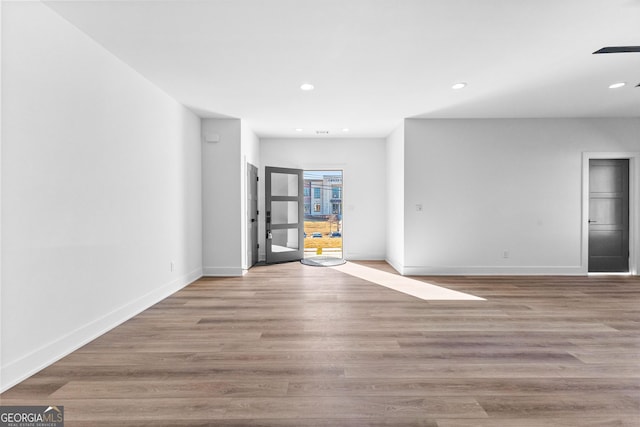 empty room with recessed lighting, baseboards, and wood finished floors
