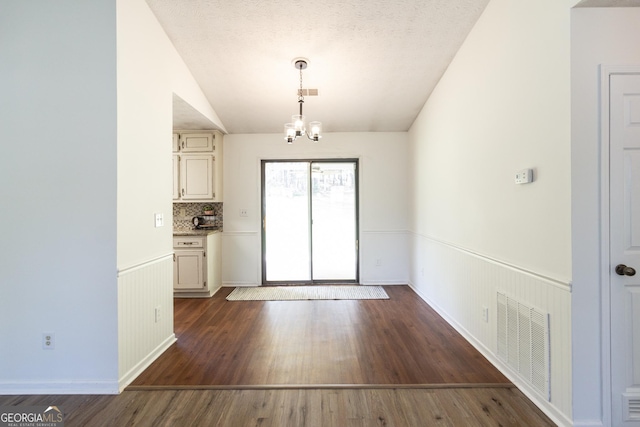 260 Peachtree Ln, Newnan, GA 30265 - unfurnished dining area featuring a chandelier, lofted ceiling, dark wood finished floors, and a wainscoted wall