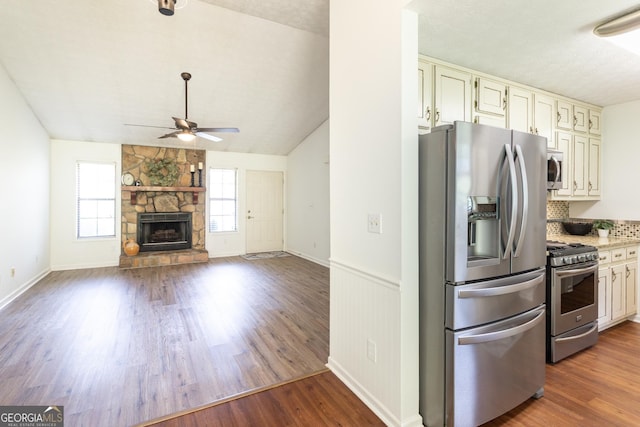 260 Peachtree Ln, Newnan, GA 30265 - kitchen featuring appliances with stainless steel finishes, ceiling fan, a stone fireplace, wood finished floors, and vaulted ceiling