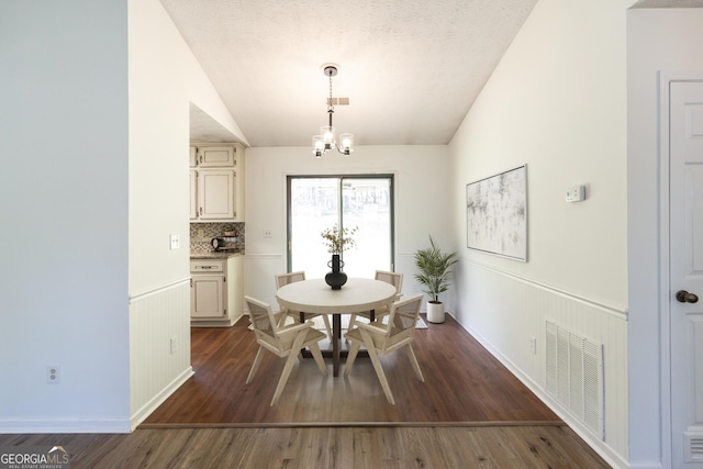 260 Peachtree Ln, Newnan, GA 30265 - dining room with lofted ceiling, a chandelier, dark wood finished floors, and a wainscoted wall