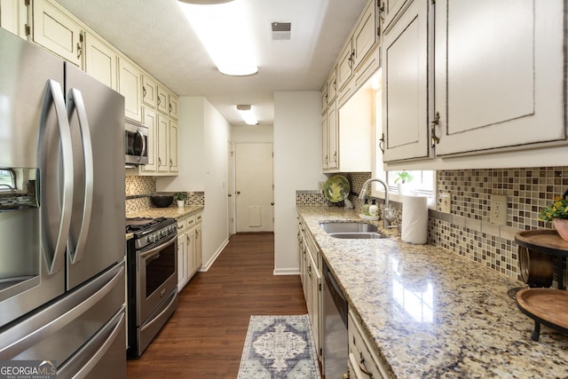 260 Peachtree Ln, Newnan, GA 30265 - kitchen featuring stainless steel appliances, a sink, dark wood finished floors, backsplash, and light stone countertops