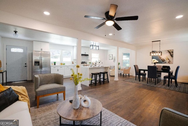 living area featuring dark wood-type flooring, ceiling fan, and recessed lighting