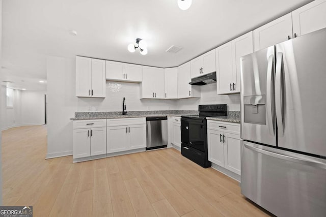 kitchen featuring under cabinet range hood, a sink, light wood-style floors, white cabinets, and appliances with stainless steel finishes