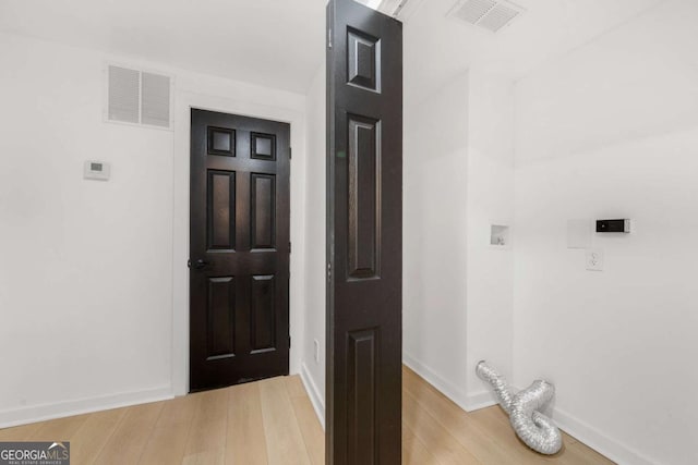 laundry room with baseboards, light wood-style floors, laundry area, and visible vents