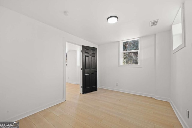 unfurnished room with light wood-type flooring, baseboards, and visible vents