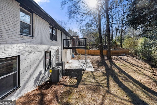 view of yard featuring central air condition unit and a wooden deck