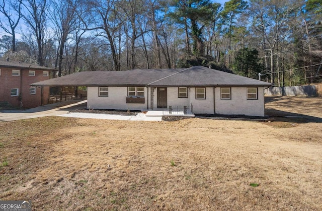 view of front facade with an attached carport, a front lawn, and concrete driveway