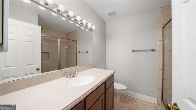 full bathroom featuring visible vents, a shower stall, toilet, vanity, and tile patterned flooring
