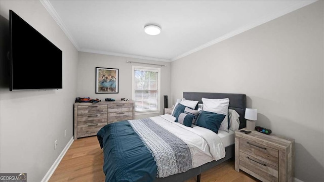 bedroom featuring baseboards, ornamental molding, and light wood-style flooring