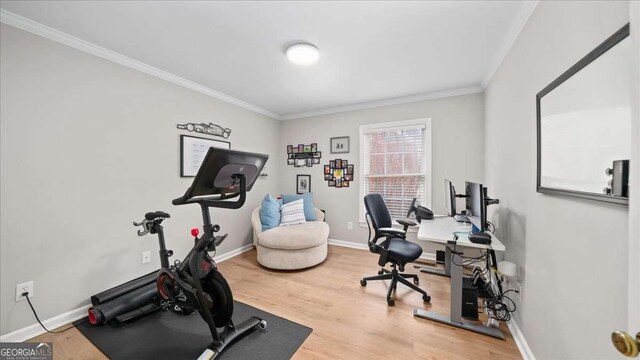 workout room featuring baseboards, wood finished floors, and ornamental molding