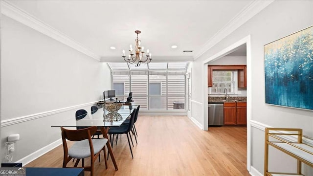 dining room featuring an inviting chandelier, ornamental molding, baseboards, and light wood-type flooring