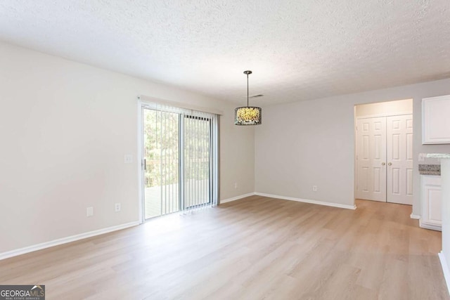 1924 Sweet Flag Rd, Lawrenceville, GA 30045 - unfurnished dining area featuring light wood-style floors, a textured ceiling, and baseboards