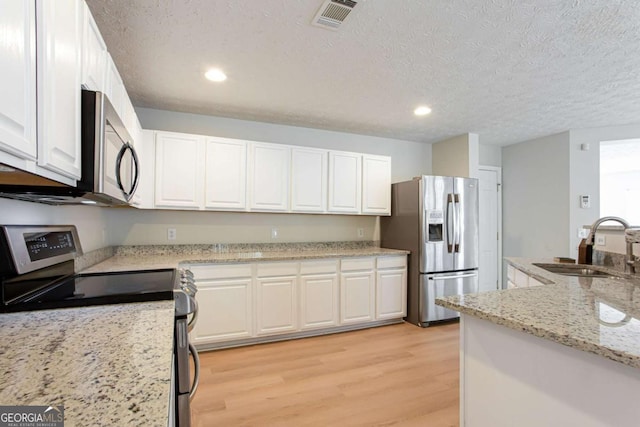 1924 Sweet Flag Rd, Lawrenceville, GA 30045 - kitchen featuring stainless steel appliances, a sink, light wood-style floors, white cabinetry, and recessed lighting