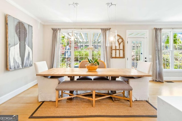 dining area featuring light wood finished floors, visible vents, and crown molding