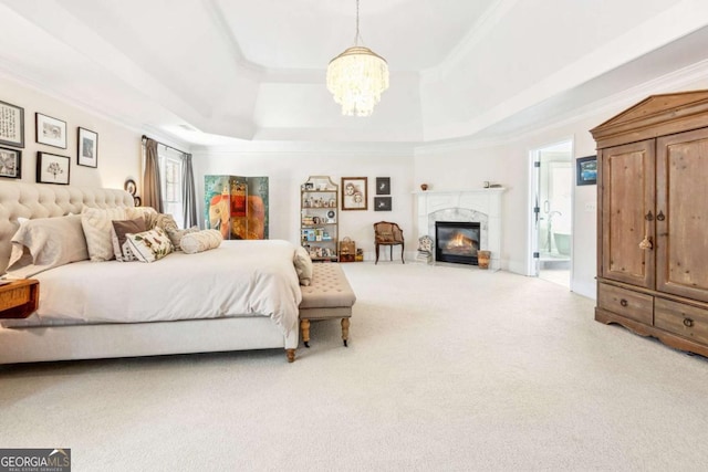 bedroom with a tray ceiling, a premium fireplace, an inviting chandelier, ornamental molding, and carpet floors