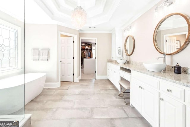 full bath with vanity, crown molding, an inviting chandelier, a spacious closet, and a soaking tub