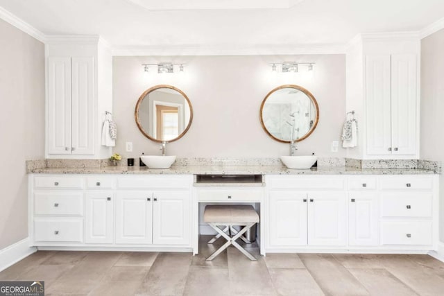 full bathroom with double vanity, a sink, crown molding, and baseboards