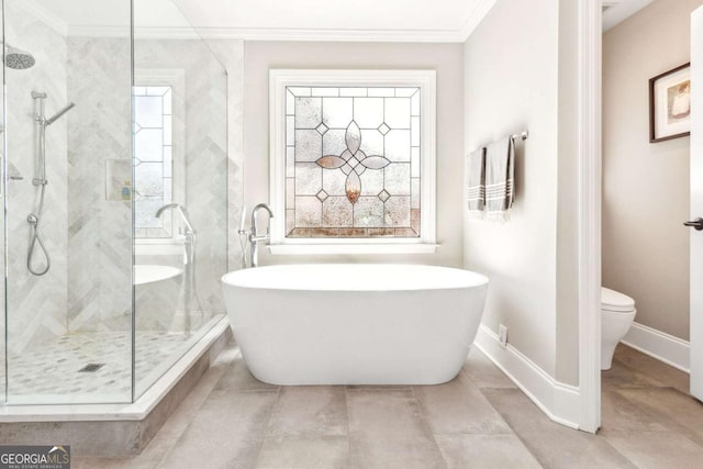 bathroom with ornamental molding, toilet, a stall shower, and a soaking tub