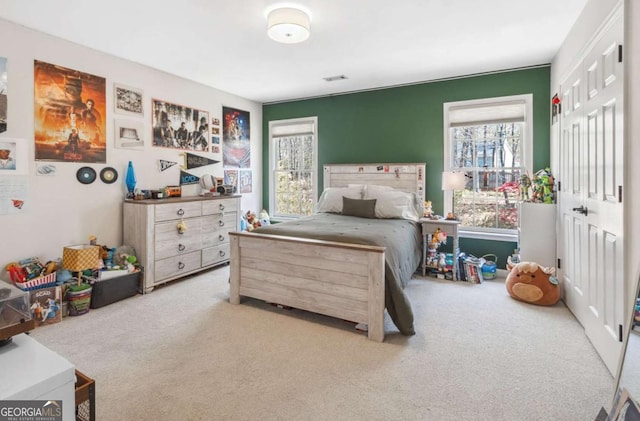 carpeted bedroom featuring a closet and visible vents