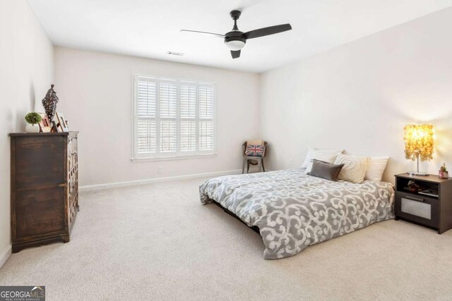 carpeted bedroom with a ceiling fan, baseboards, and visible vents
