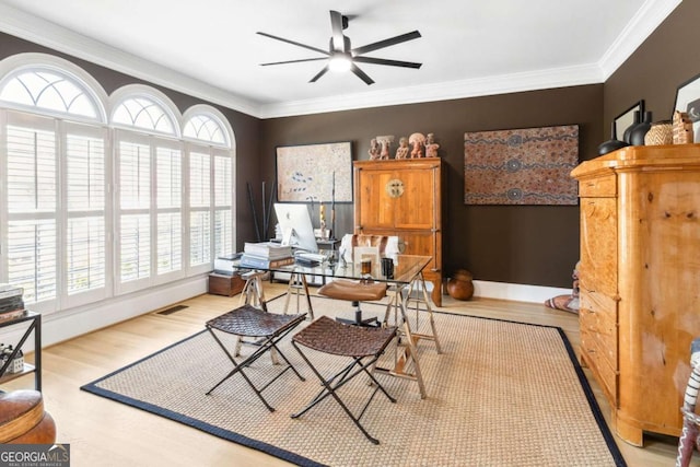 office area featuring crown molding, baseboards, visible vents, a ceiling fan, and wood finished floors
