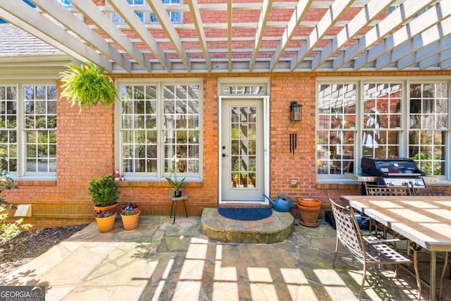entrance to property with a patio, brick siding, and outdoor dining area