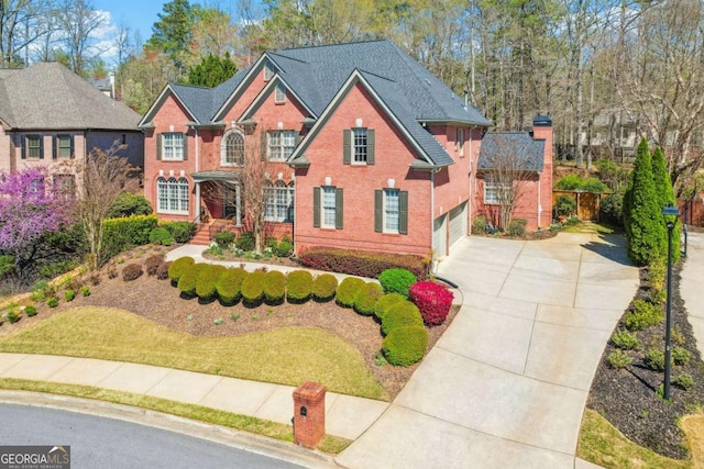 view of front of home featuring an attached garage, concrete driveway, and brick siding