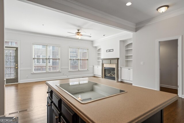 kitchen with dark wood-type flooring, a premium fireplace, open floor plan, black electric cooktop, and ornamental molding