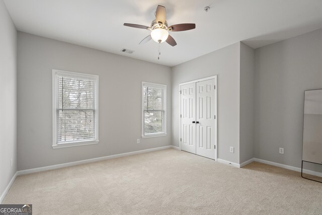 unfurnished bedroom featuring baseboards, carpet floors, and a closet