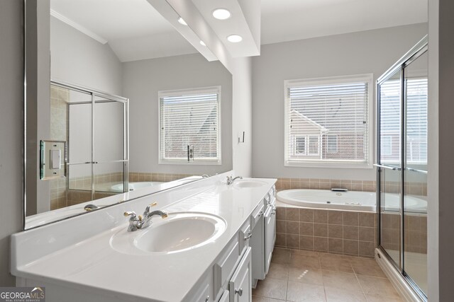 bathroom featuring tile patterned floors, a sink, and a garden tub