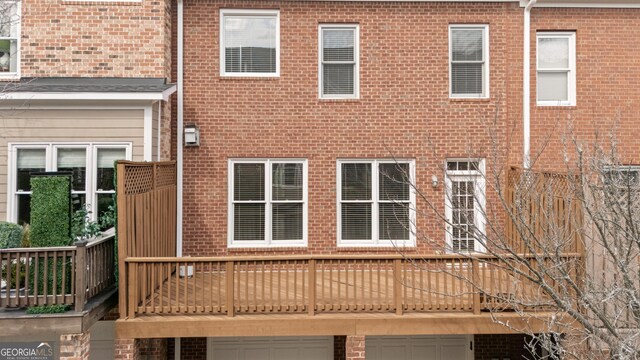 back of property with an attached garage and brick siding