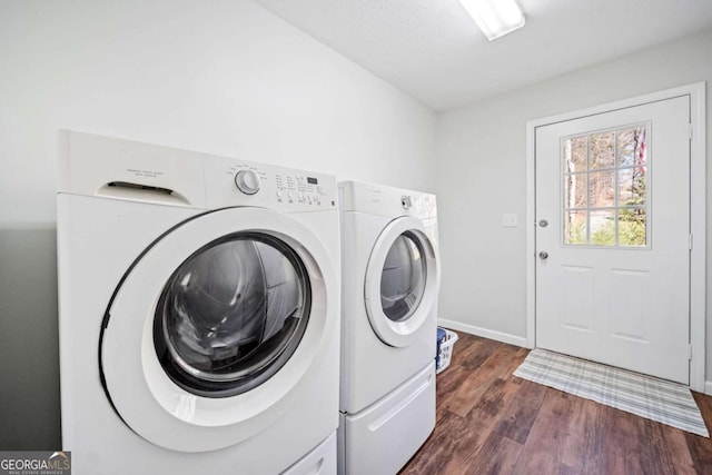 laundry area featuring dark wood finished floors, baseboards, washer and dryer, and laundry area