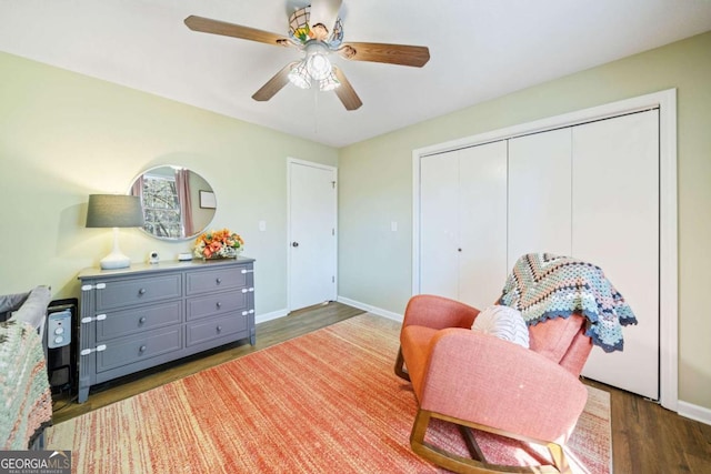living area featuring a ceiling fan, baseboards, and wood finished floors