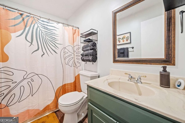 bathroom featuring toilet, vanity, and curtained shower